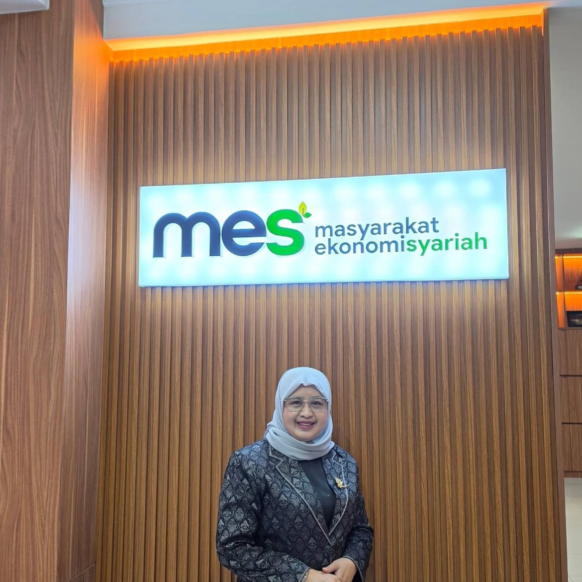 Prof Euis Amalia di depan logo MES